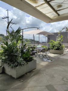 um pátio com uma mesa, um guarda-chuva e plantas em CV Industrial Place em Antipolo