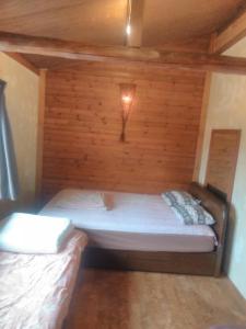 Rustic Resort Isumi / Vacation STAY 5447 في Isumi: غرفة صغيرة مع سرير في جدار خشبي