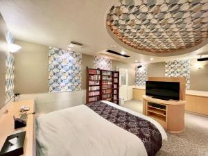 um quarto com uma cama e uma televisão de ecrã plano em SKY Lmine Takeo LOVEHOTEL em Takeo