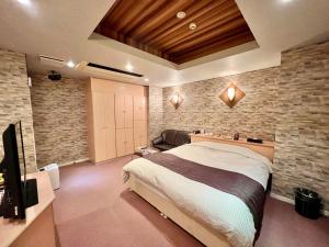 um quarto com uma cama grande e uma parede de pedra em SKY Lmine Takeo LOVEHOTEL em Takeo