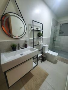 een badkamer met een wastafel, een spiegel en een toilet bij Escapada en Boca chica in Boca Chica