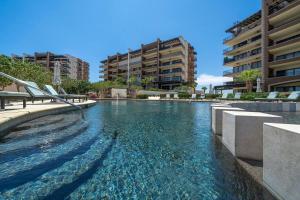 a swimming pool with blue water in a building at Stunning 3BR Condo with Ocean Views, Golf Course & Resort Amenities in Cabo San Lucas