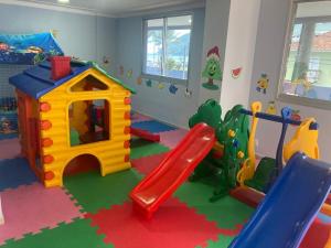 a childrens play room with a slide and a playground at Apto em Bertioga , pé na areia in Bertioga