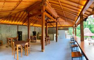 una sala da pranzo con tavoli, sedie e un grande soffitto in legno di Kampoeng Joglo Ijen a Banyuwangi