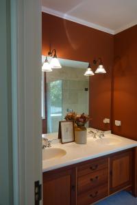 ein Badezimmer mit Waschbecken und großem Spiegel in der Unterkunft Ocean Beach Residence in Tuki Tuki