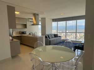 a kitchen and living room with a table and chairs at Apartamento 01 quadra da praia - LUXO Praiamar Residence in Santos