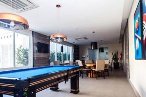 a pool table in a room with a dining room at Apartamento 01 quadra da praia - LUXO Praiamar Residence in Santos
