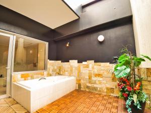 uma casa de banho com uma banheira e uma parede de azulejos em SKY Lmine Takeo LOVEHOTEL em Takeo
