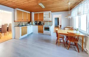 a kitchen with wooden cabinets and a table and chairs at Nice Home In Torup With Wifi in Torup