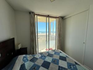 una camera con letto e vista sulla spiaggia di Departamento El Tabo a Las Cruces