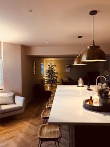 una sala de estar con un árbol de Navidad y una cocina en Immaculate 6 Bed House - Unique Cellar Bar- Airbnb en Warminster