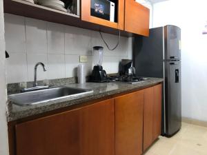 een keuken met een gootsteen en een roestvrijstalen koelkast bij cómodo apartamento 3 alcobas in Barranquilla