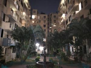 een binnenplaats met palmbomen en gebouwen 's nachts bij cómodo apartamento 3 alcobas in Barranquilla