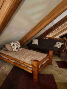 een houten bed op een zolder met een dak bij Chapel Forest Cabin in Shingleton