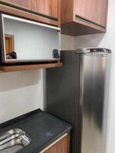 une cuisine avec un réfrigérateur en acier inoxydable et des armoires en bois dans l'établissement Apartamento Lindo e Aconchegante, à São José