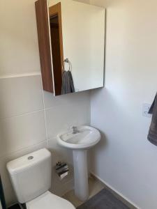 a bathroom with a toilet and a sink and a mirror at Apartamento Lindo e Aconchegante in São José