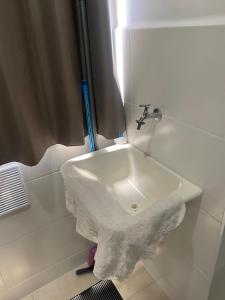a white sink in a bathroom with a faucet at Apartamento Lindo e Aconchegante in São José