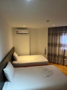 2 łóżka pojedyncze w pokoju z oknem w obiekcie One Dream Hotel w mieście Petaling Jaya