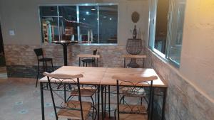 een tafel en stoelen in een bar met een raam bij Recanto Itália Brasil in Biritiba-Mirim