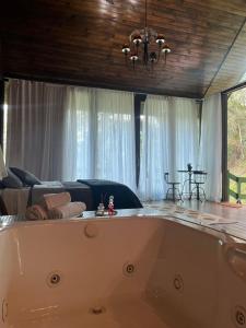 Recanto dos Sonhos Guest House في لوميار: حوض استحمام في غرفة معيشة مع أريكة