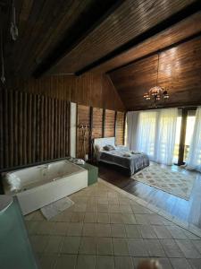 a large bathroom with a bath tub and a bed at Recanto dos Sonhos Guest House in Lumiar