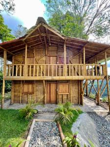 une grande maison en bois avec une grande terrasse dans l'établissement Cabaña Bamboo House, à Calarcá