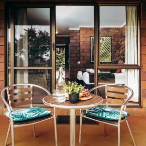 a table with two chairs and a bowl of fruit on it at Malanda Lodge in Malanda