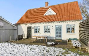 una casa de techo naranja con una mesa delante en Awesome Home In Tranekr With Kitchen, en Tranekær