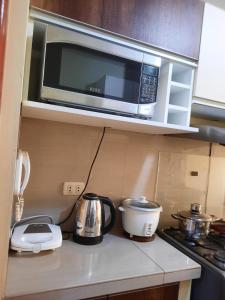 La Victoria的住宿－Apartamentos Los Incas，厨房配有微波炉和台面上的咖啡壶