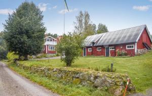 a red barn with a gray roof on a grassy hill at Cozy Home In Tving With Wifi in Tving