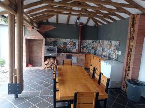 a dining room with a wooden table and a kitchen at Quinta Villateo in Villavicencio