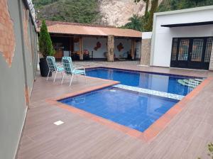 a swimming pool with two chairs next to a house at Quinta Villateo in Villavicencio