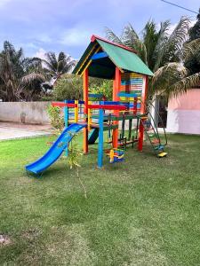 un parque infantil con tobogán y estructura de juegos en Casa Marudá en Marapanim