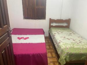 Duas camas num pequeno quarto com uma janela em Casa Marudá em Marapanim