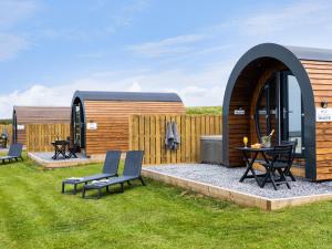 a backyard with a gazebo and a table and chairs at Traeth Pod - Uk46077 in Towyn