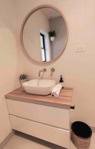 a bathroom with a sink and a mirror at Coastal 3 bedroom house with private oasis. in Mona Vale