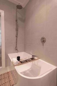 a bathroom with a shower with a white tub at Coastal 3 bedroom house with private oasis. in Mona Vale