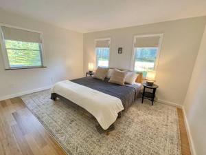 um quarto com uma cama grande e 2 janelas em Quiet Family Friendly Home w/ Backyard [Owls Nest] em Tremont