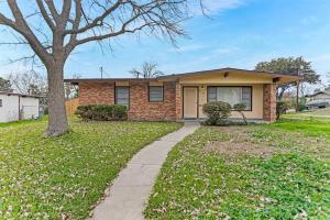 a brick house with a tree and a sidewalk at Fenced backyard, king bed, near medical center, Aquarium, and SeaWorld in San Antonio
