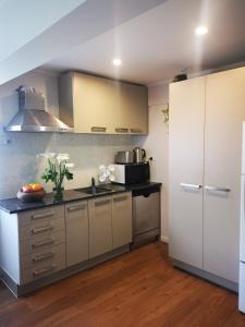 cocina con armarios blancos y encimera en Nice house on Wesley Auckland, en Auckland