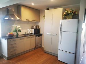 a kitchen with white appliances and a refrigerator at Nice house on Wesley Auckland in Auckland