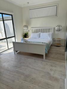 a bedroom with a large bed and a large window at Terrigal Beach House in Terrigal