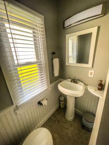 W łazience znajduje się umywalka, toaleta i lustro. w obiekcie Cozy Pond Side Cottage in Bar Harbor! [The Nook] w mieście Bar Harbor