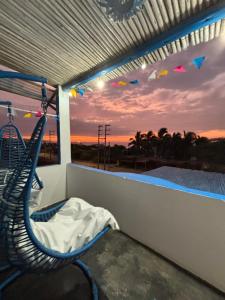 a room with a hammock on a balcony with a sunset at Villa Aqua Boutique Vichayito in Vichayito