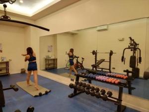 2 femmes faisant de l'exercice dans une salle de sport avec miroir dans l'établissement Savannah Resort Hotel, à Ángeles
