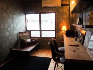 um quarto com uma mesa de madeira e uma janela em ゲストホテル宰嘉庵あおい/GuestHotelSAIKAAN_AOI em Maizuru