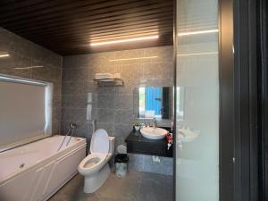 a bathroom with a toilet and a tub and a sink at Moc Chau Home in Làng Môn