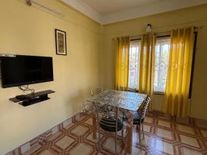 a dining room with a table and a tv at Nivriti (Bliss) Homestay in Guwahati