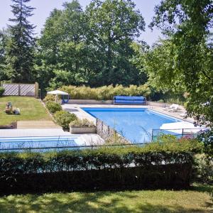 a large swimming pool in a yard with trees at Domaine de Keravel in Plouha