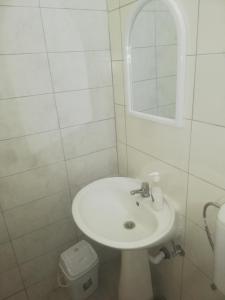 a white bathroom with a sink and a mirror at Hostel Vintage in Ohrid